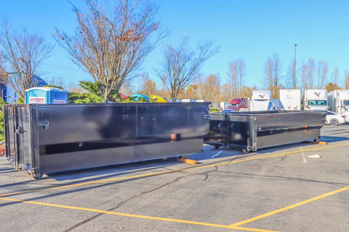 Professional dumpster rental service with roll-off container on residential driveway in Fort Edward